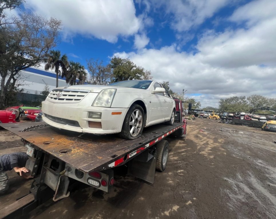 Flatbed tow truck hauling a damaged Chrysler 300 junk car in Louisville